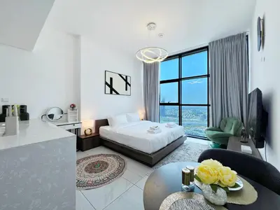 a bedroom with a bed and a table in a room at Modern Studio with Stunning City Views in Dubai