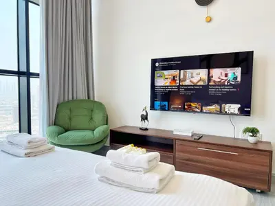 a hotel room with a bed with a tv and a chair at Modern Studio with Stunning City Views in Dubai