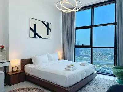 a bedroom with a bed and a large window at Modern Studio with Stunning City Views in Dubai