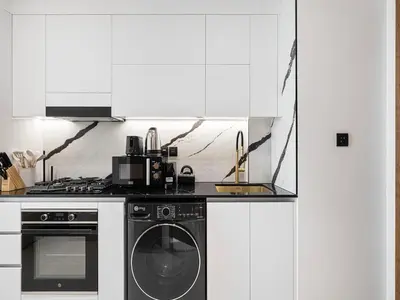 a kitchen with a stove and a washer and dryer at Daniels Studio with Private Jacuzzi & Canal View in Dubai