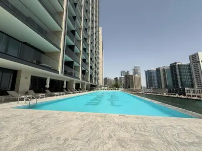 a swimming pool on the roof of a building with a city at Daniels Studio with Private Jacuzzi & Canal View in Dubai