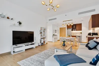 a living room with a large flat screen tv at Stylish 1BR Port De La Mer Escape with Beach Access in Dubai