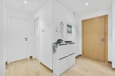 a kitchen with white walls and a wooden door at Stylish 1BR Port De La Mer Escape with Beach Access in Dubai