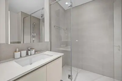 a bathroom with a sink and a glass shower at Spacious 1 bedroom in creek beach-Huge Balcony in Dubai