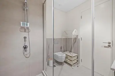 a bathroom with a toilet and a glass shower at Spacious 1 bedroom in creek beach-Huge Balcony in Dubai