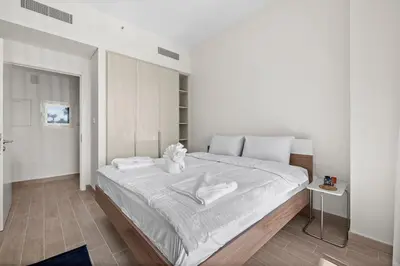 a white bedroom with a large bed with white sheets at Spacious 1 bedroom in creek beach-Huge Balcony in Dubai