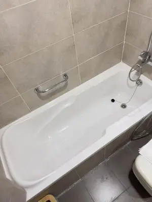 a white bath tub in a tiled bathroom at Damac Carson B Studio, Scenic & Serene Stay in Dubai