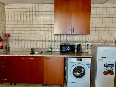 a kitchen with a sink and a washing machine at Motor City Shakespeare Circus in Dubai