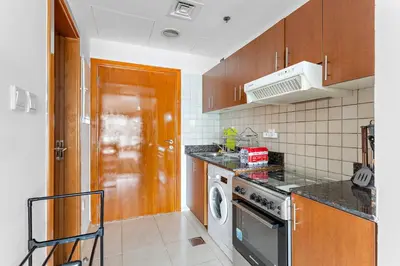 a kitchen with a stove and a washer and dryer at Modern Studio in Skycourts, Near Dubai Outlet Mall in Dubai