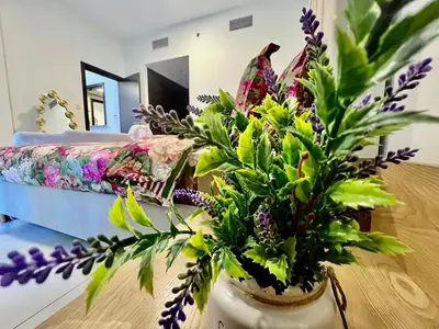 a vase with flowers on a table in a room at Jaddaf Pool Gym Parking in Dubai