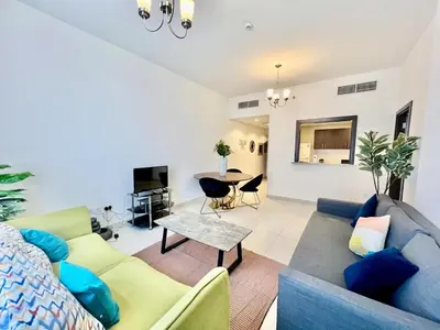 a living room with a couch and a table at Jaddaf Pool Gym Parking in Dubai