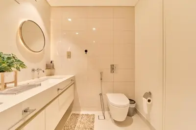 a white bathroom with a toilet and a mirror at Luxury 2BR in Beach Vista With Stunning Palm Views in Dubai