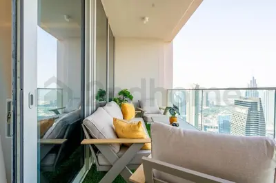 a room with a balcony with a couch and a table at Burj Khalifa view, 3 Bedroom, Maids Room, Forte in Dubai