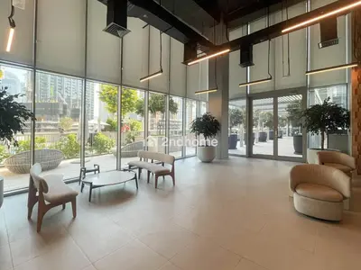 a lobby with chairs and tables and windows at Burj Khalifa view, 3 Bedroom, Maids Room, Forte in Dubai
