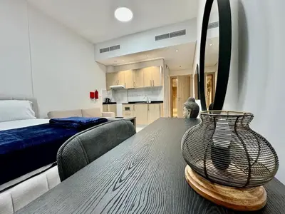 a table with a vase on it in a bedroom at Sleep 3 Walk to ADCB metro in Dubai