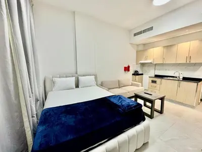 a bedroom with a large bed and a kitchen at Sleep 3 Walk to ADCB metro in Dubai