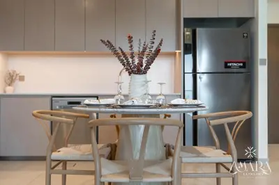 a kitchen with a table with chairs and a refrigerator at Grande Luxury, Burj Khalifa & Fountain View in Dubai