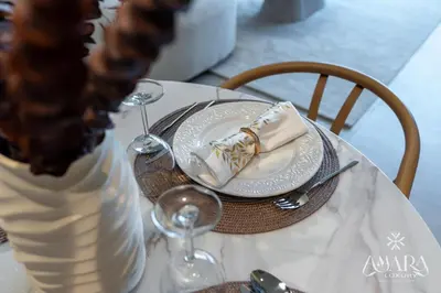 a table with a plate with a napkin and wine glasses at Grande Luxury, Burj Khalifa & Fountain View in Dubai
