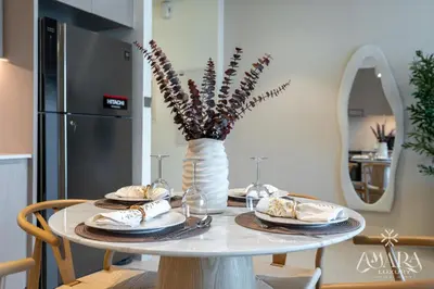 a table with plates and a vase with flowers on it at Grande Luxury, Burj Khalifa & Fountain View in Dubai