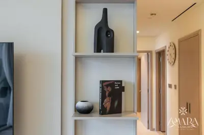 a shelf in a room with a vase and a book at Grande Luxury, Burj Khalifa & Fountain View in Dubai