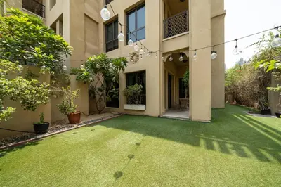 an empty courtyard of a house with a grass yard at Stylish Old Town 1 Bed Plus Maids with Private Garden in Dubai