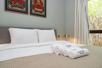 a bed with three rolled towels on top of it at Stylish Old Town 1 Bed Plus Maids with Private Garden in Dubai
