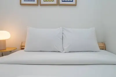 a bed with a white pillow on top of it at Stylish Old Town 1 Bed Plus Maids with Private Garden in Dubai