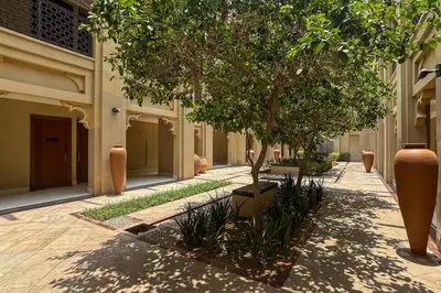 a courtyard with a tree in a building at Stylish Old Town 1 Bed Plus Maids with Private Garden in Dubai