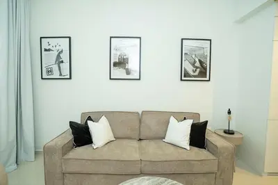 a living room with a couch and pictures on the wall at High-Floor 2BR - Aykon City 2BR in Business Bay in Dubai