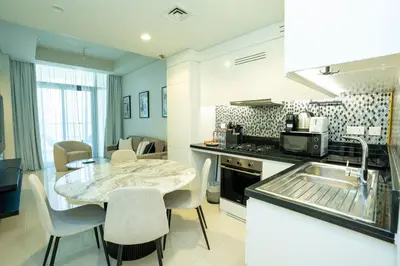 a kitchen with a table and chairs and a sink at High-Floor 2BR - Aykon City 2BR in Business Bay in Dubai