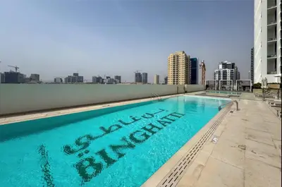 a swimming pool on the roof of a building at Brand New 1BR Near Parks and Mall JVC in Dubai