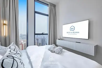 a bedroom with a bed with a tv on the wall at Luxury 1B - CityView Near Parks and Mall JVC in Dubai