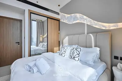 a bedroom with a white bed and a mirror at Luxury 1B - CityView Near Parks and Mall JVC in Dubai