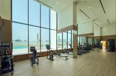 a gym with a lot of treadmills and exercise bikes at Luxury 1B - CityView Near Parks and Mall JVC in Dubai