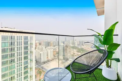 a balcony with two chairs and a view of a city at Binghatti Gardenia 1BR - Near Parks and Mall JVC in Dubai