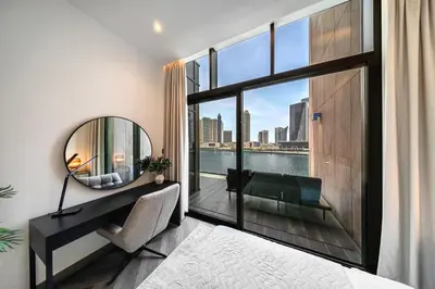 a bedroom with a large window with a view of the city at Peninsula Five 3BD Duplex with Lake view, For 9 in Dubai