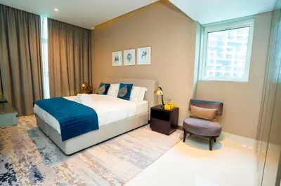 a bedroom with a large bed and a chair at Charming Studio and Perfect Stay with Gym and Pool in Dubai