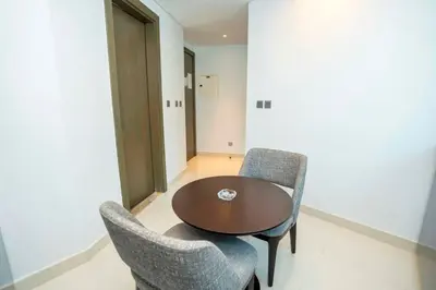 a room with a wooden table and two chairs at Charming Studio and Perfect Stay with Gym and Pool in Dubai