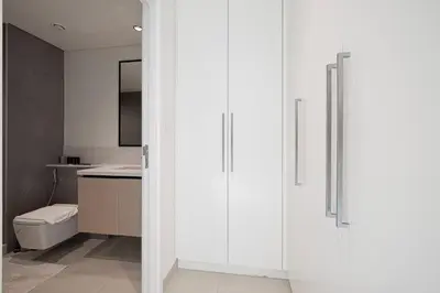 a white bathroom with a toilet and a sink at Exceptional 2 Bedroom Apartment! High Floor! Amazing Rooftop! Burj Crown by Emaar in Dubai
