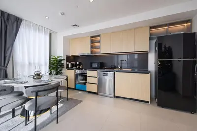 a kitchen with a table and a black refrigerator at Exceptional 2 Bedroom Apartment! High Floor! Amazing Rooftop! Burj Crown by Emaar in Dubai