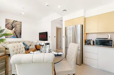 a kitchen and living room with a table and chairs at Spacious 4BR Villa with Private Garden & Patio in Nadd Shubayḩ