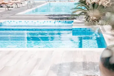 a swimming pool with blue water in a resort at Urban 1BR Stay, Walk to Downtown & Canal in Dubai