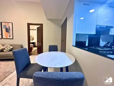 a living room with a table and two chairs at Urban 1BR Stay, Walk to Downtown & Canal in Dubai