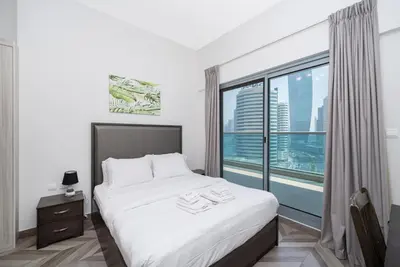 a bedroom with a bed and a large window at Family-Friendly 4BR with Amenities Business Bay in Dubai