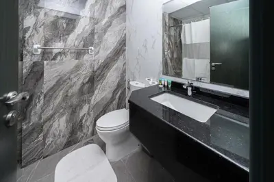 a bathroom with a sink and a toilet and a mirror at Family-Friendly 4BR with Amenities Business Bay in Dubai