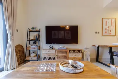 a living room with a table and a flat screen tv at Oasis in the heart of Downtown in Dubai