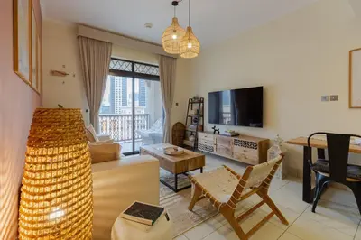 a living room with a couch and a tv at Oasis in the heart of Downtown in Dubai