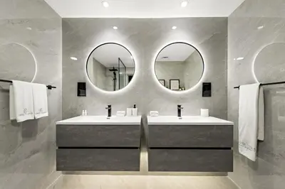 a bathroom with two sinks and two mirrors at JBR 3BR Palm Jumeirah & Sea Views, Pool & Gym Access in Dubai