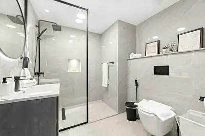 a bathroom with a toilet and a sink and a shower at JBR 3BR Palm Jumeirah & Sea Views, Pool & Gym Access in Dubai