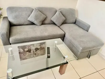 a couch in a living room with a glass table at Not far from metro and WTC in Dubai